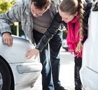 Family checking out damage after car accident